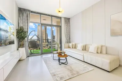 a white living room with a couch and a table at FIRST CLASS 2BR Downtown Glam Burj View in Dubai