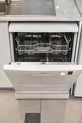 an open dishwasher with dishes inside of it in a kitchen at Modern 1BR Apartment Lamtara 3 in MJL in Dubai