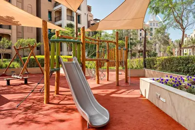 a playground with a slide in a park at Modern 1BR Apartment Lamtara 3 in MJL in Dubai