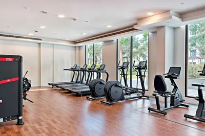 a gym with a row of treadmills and ellipticals at Modern 1BR Apartment Lamtara 3 in MJL in Dubai