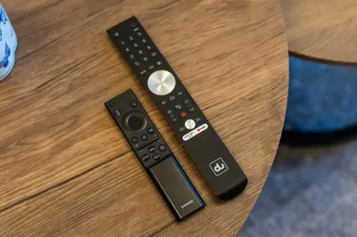 a remote control sitting on top of a table at Bright 2BR Sports City Near Miracle GardenParks in Dubai