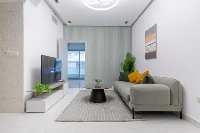 a living room with a couch and a tv at Dubai Marina - 1BHK Modernistic Apartment in Dubai