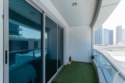 a balcony with glass doors and a view of the city at Dubai Marina - 1BHK Modernistic Apartment in Dubai