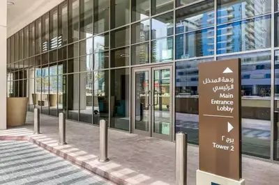 a large glass building with a sign in front of it at Vogue Downtown Bellevue Towers near Burj Khalifa and Dubai Mall, One Bedroom Apartment with Balcony and City View, Full Access to all Amenities in Dubai