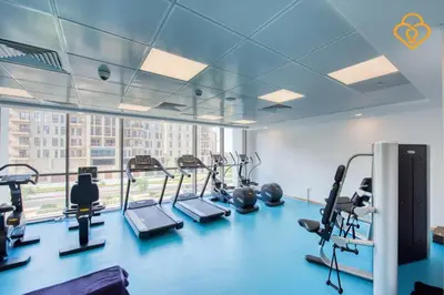 a gym with tread machines and a large window at Keysplease Great Family 2 BR Apt, Townsquare in Dubai