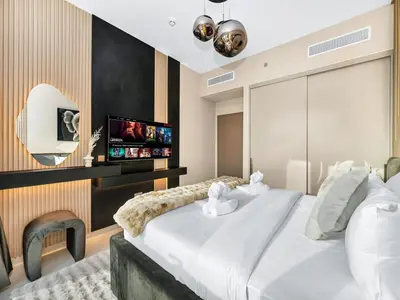 a bedroom with a large white bed and a flat screen tv at 51st Floor Sea and Skyline Views LUXE 1BR in Dubai