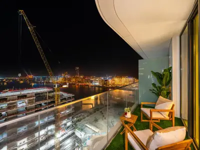 a balcony with a view of a city at night at Chic 1 Bedroom with Palm Views in Palace Beach Residence in Dubai
