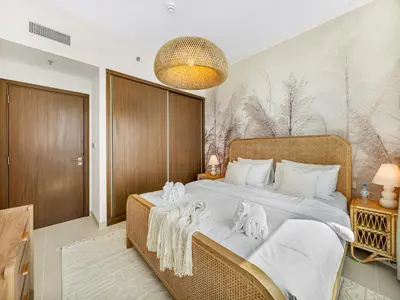 a bedroom with a large bed with towels on it at Chic 1 Bedroom with Palm Views in Palace Beach Residence in Dubai