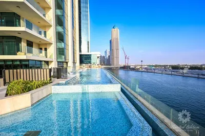 a swimming pool in the middle of a river with buildings at Luxury Apartments - Urban Oasis by Missoni - Business Bay - Canal View - 10 Minutes from Dubai Mall Burj Khalifa in Dubai