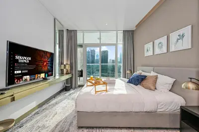 a bedroom with a large bed and a flat screen tv at Canal View Studio near Dubai Mall in Dubai