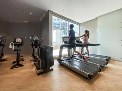two people running on a treadmill in a gym at Canal View Studio near Dubai Mall in Dubai