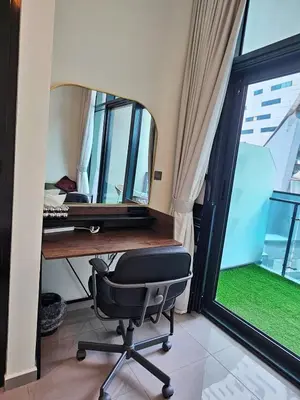 a desk with a chair in a room with a window at Merano Studio 920 in Dubai