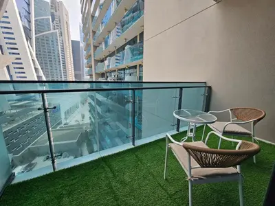 a balcony with two chairs and a table on a building at Merano Studio 920 in Dubai