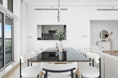 a white dining room with a table and chairs at Luxury 4BR w Marina Views Near Beach & Mall in Dubai