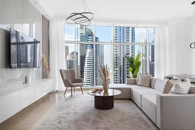 a living room with a white couch and a large window at Luxury 4BR w Marina Views Near Beach & Mall in Dubai
