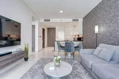 a living room with a couch and a table at PVH - Lagoon View 1BR - District One in Dubai