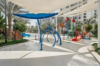 a playground at a resort with a blue swing at Creek Home with Private Terrace & Direct Pool Access in Dubai