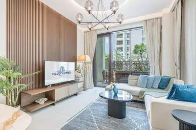 a living room with a couch and a tv at Creek Home with Private Terrace & Direct Pool Access in Dubai