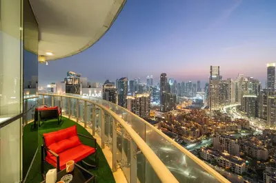 a red chair on a balcony with a city skyline at Panoramic Burj Khalifa View - Damac Distinction Downtown Dubai in Dubai