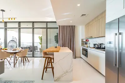 a kitchen with a table and a dining room at Luxury Stay, 3BR Palm View, Beach Vista in Dubai