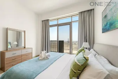 a bedroom with a bed and a large window at Modern 1-Bedroom Apartment in Al Furjan With Pool & Gym in Dubai