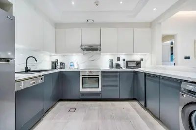 a large kitchen with blue cabinets and appliances at DAYF-FMT Fairmont Palm with Pool and Beach Access in Dubai