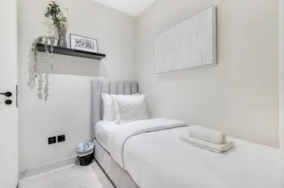 a white bedroom with a bed with white sheets at DAYF-FMT Fairmont Palm with Pool and Beach Access in Dubai