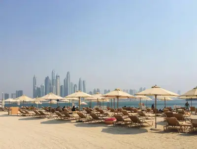 a group of chairs and umbrellas on a beach at DAYF-FMT Fairmont Palm with Pool and Beach Access in Dubai