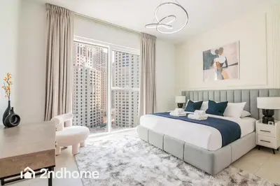 a bedroom with a bed and a desk and a window at Newly Furnished, Beach Access located in La Vie, JBR in Dubai
