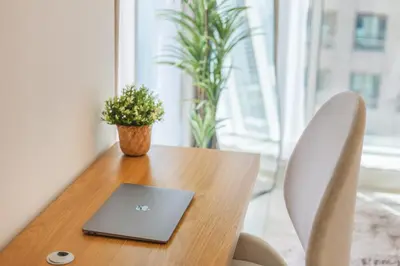 a wooden table with a laptop on top of it at Luxury 3BR Gem in the Heart of Dubai Marina in Dubai