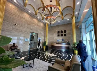 a lobby with a chandelier and people in a building at Luxury 3BR Gem in the Heart of Dubai Marina in Dubai