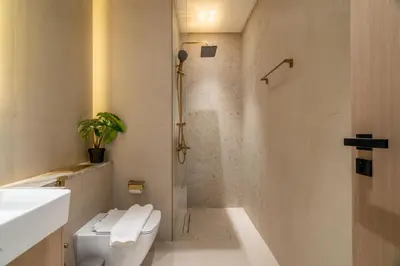 a bathroom with a shower and a toilet and a sink at New! Stylish Studio with Pool, Gym & Jacuzzi, JVC in Dubai