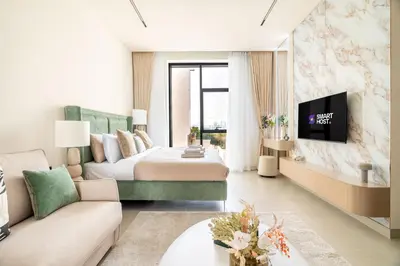 a hotel room with a bed and a tv at New! Stylish Studio with Pool, Gym & Jacuzzi, JVC in Dubai