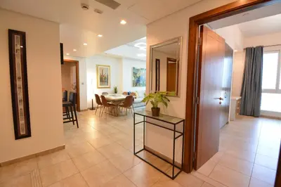 a hallway with a table and a dining room at Near to Nakheel Mall Swimming Pool and Sea View in Dubai