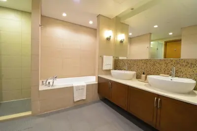 a bathroom with two sinks and a tub and a mirror at Near to Nakheel Mall Swimming Pool and Sea View in Dubai