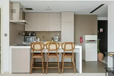 a kitchen with three chairs at a kitchen island at DAYF-WST Stunning Marina Views at Marina Promenade in Dubai
