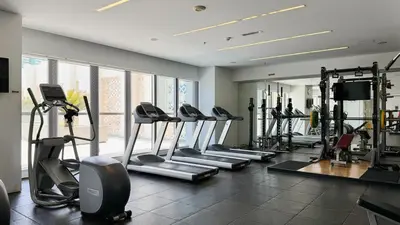 a gym with a row of treadmills and machines at DAYF-WST Stunning Marina Views at Marina Promenade in Dubai