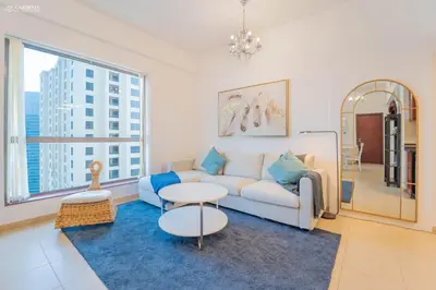 a living room with a couch and a table at Gardenia Bahar Suites 1 Bedroom Apartment in JBR with 2 mins walk to the Beach in Dubai