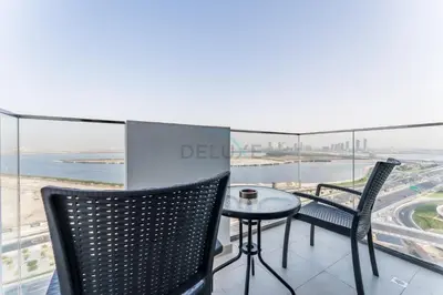 a balcony with a table and chairs and a view of the ocean at 1BR with Dubai Creek Views, Near Dubai Frame And Zabeel Park, Fawad Azizi Residence, Al Jadaf by Deluxe Holiday Homes in Dubai