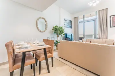 a dining room and living room with a table and chairs at 1BR with Dubai Creek Views, Near Dubai Frame And Zabeel Park, Fawad Azizi Residence, Al Jadaf by Deluxe Holiday Homes in Dubai