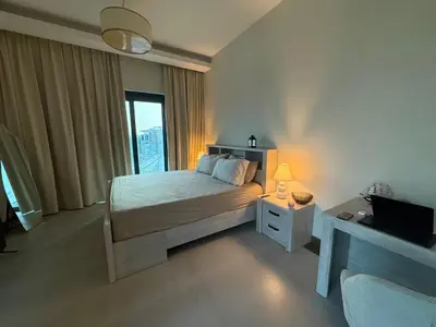 a bedroom with a bed and a tv and a window at Luxury Stay Dual View Furnished Swimming Pool Gym in Dubai
