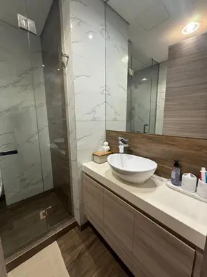 a bathroom with a sink and a glass shower at Luxury Stay Dual View Furnished Swimming Pool Gym in Dubai