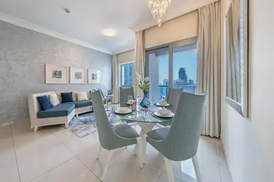 a living room with a table and chairs and a couch at 2min to Dubai Mall - Pool, Gym, Sauna - Full Burj View in Dubai