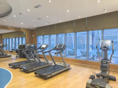 a gym with treadmills and ellipticals in a building at 2min to Dubai Mall - Pool, Gym, Sauna - Full Burj View in Dubai