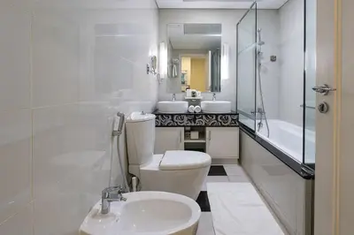 a bathroom with a toilet and a sink and a tub at 2min to Dubai Mall - Pool, Gym, Sauna - Full Burj View in Dubai