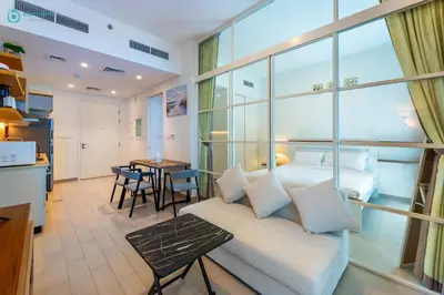 a living room with a couch and a bed and a table at Blue Breeze - Modern 1BR, Dubai Hills, in Dubai