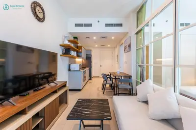 a living room with a couch and a table at Blue Breeze - Modern 1BR, Dubai Hills, in Dubai