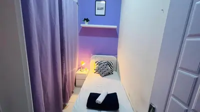 a small room with a bed with purple walls at Solo Stay Partition Room in Al Barsha 1 in Dubai