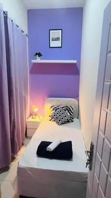 a purple room with a bed with a phone on it at Solo Stay Partition Room in Al Barsha 1 in Dubai