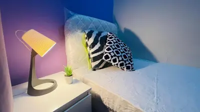 a bedroom with a bed with a lamp and pillows at Solo Stay Partition Room in Al Barsha 1 in Dubai